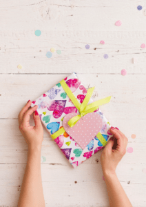 Kindergeburtstag_feiern_Muenchen_Geburtstag_Kinderfest_zuhause Geschenk verpackt in Papier mit Herzchen