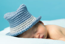 Jedes Kind schläft anders Schlafendes Baby mir gestrickem Sonnenhut