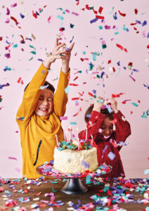 Geburtstagsratgeber-2022 Zwei Kinder und eine Geburtstagstorte im Konfetti-Regen