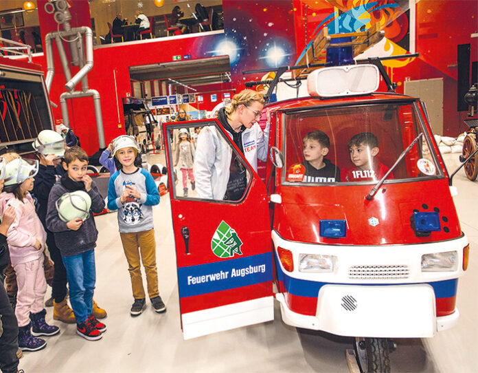 feuerwehrerlebniswelt Kinder und eine als Feuerwehrauto umgebaute Ape