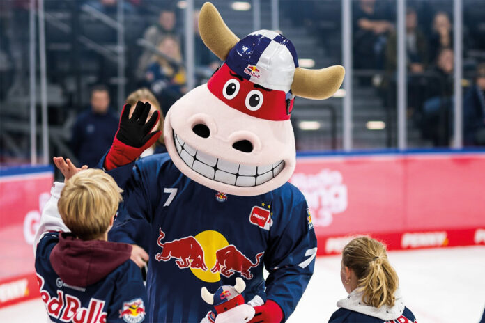 Das Maskottchen vom EHC Red Bull München mit Kindern auf dem Eis