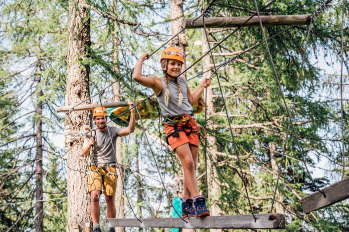 falkensteiner_sonnenalpe_outdoor_hochseilgarten Zwei Personen klettern in einem Hochseilgarten