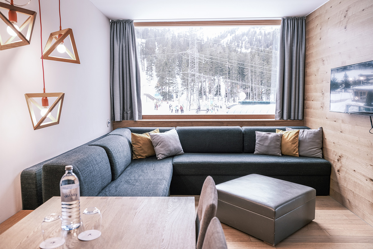 Eine Couch und ein Tisch vor einem Fenster direkt an der Piste