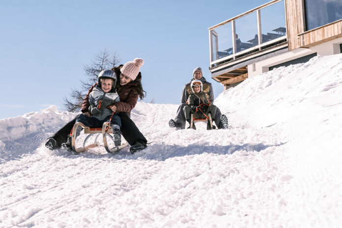 winterurlaunb_am_katschberg_active ZweinErwachsene rodeln mit einem Kind